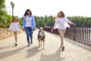 Mother and daughters walking their dog for exercise
