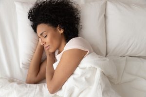 Woman sleeping peacefully in bed after following some sleep tips